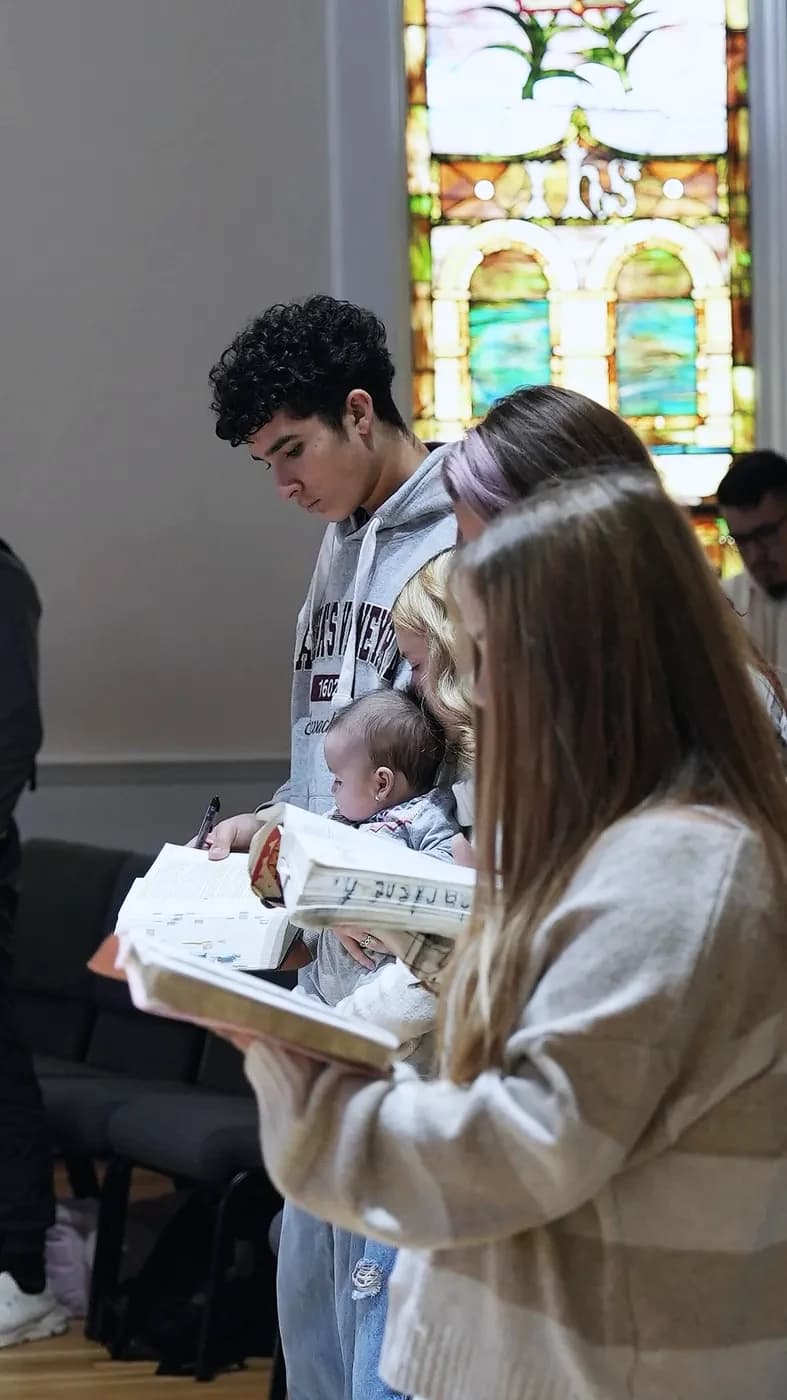 Young people reading along in open Bibles during the message