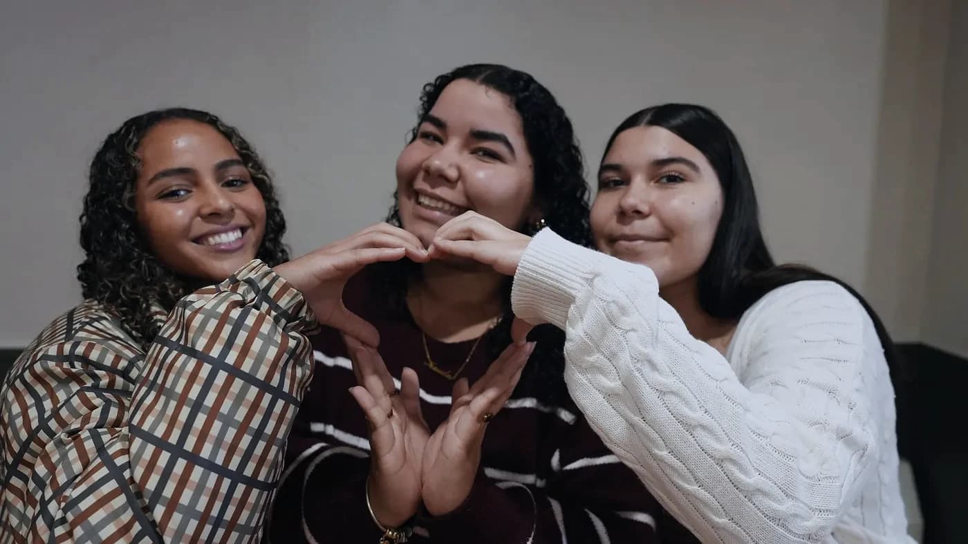 Three young women make a heart with their hands at The Way Church