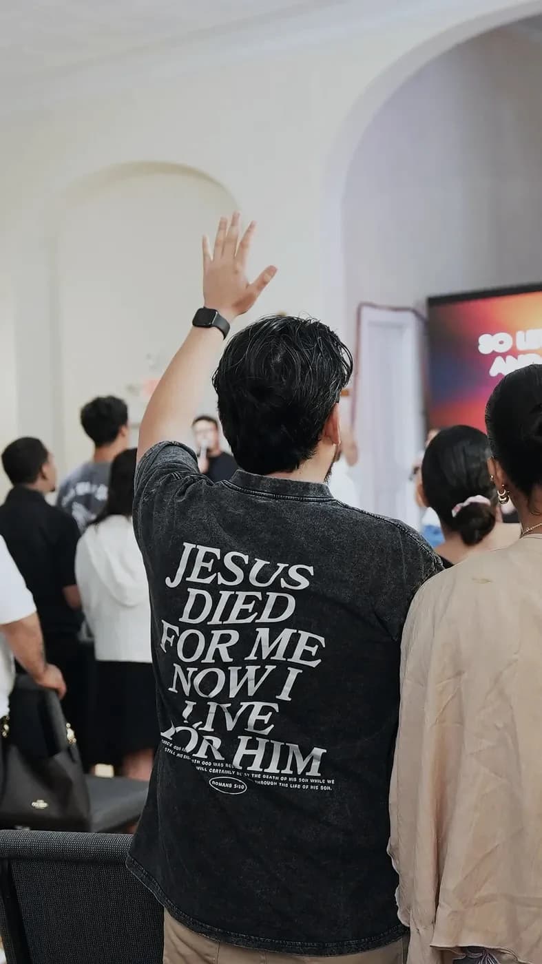 A man raises his hand in worship during a Sunday service at The Way Church in Milford, MA