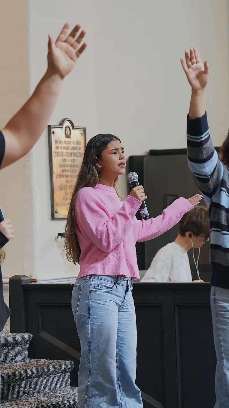 A young singer leads worship at The Way Church